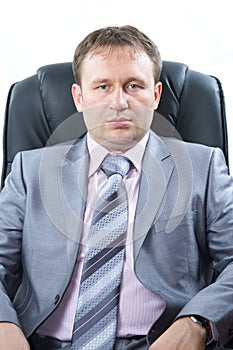 Proud business owner poses for a serious portrait on white background. Serious young business man
