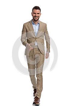 Proud businessman in beige suit shaking hand and walking