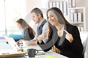 Proud businesswoman pointing himself at office