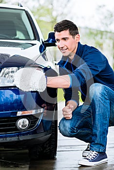 Proud car owner cleaning the headlamps