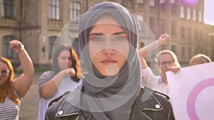 Proud caucasian young female in hijab standing near feminists voting emotionally and demonstrating power