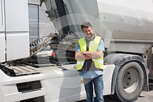 Proud driver or forwarder in front of trucks and trailers,
