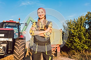 Proud famer standing in front of agricultural machinery