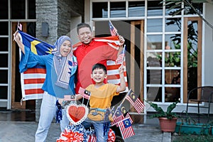 Proud family with malaysia flag and decorated bicyle