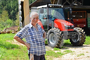 Proud farmer standing in front of his tractor