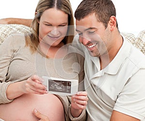 Proud future dad looking at an echography photo