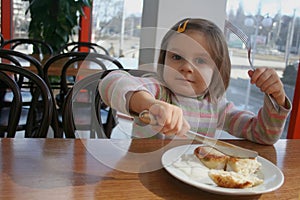 Proud girl using fork and knife