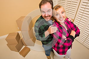 Proud Goofy Couple and Moving Boxes in Empty Room