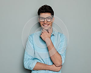 proud happy man with glasses folding arms, touching chin and thinking