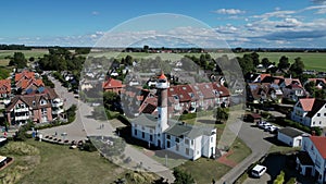Proud majestic lighthouse tower above roofs. Marvelous aerial view flight poel