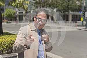 A proud middle aged man points to you, giving acknowledgment. A hip guy greeting someone while taking a stroll in the city