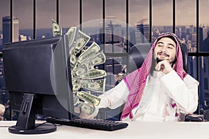 Proud muslim man looking money on monitor