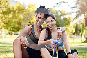 Proud of my friend. Cropped portrait of two attractive young women sitting close to each other and smiling while in the