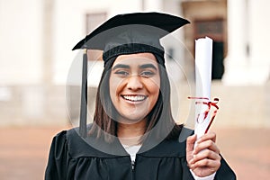 So proud of myself. a young female graduate holding her diploma.