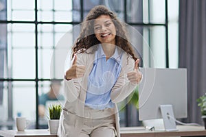 Proud office worker posing with thumbs up