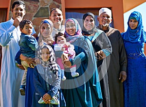 Proud of our family. Portrait of a happy muslim family standing together in front of their house.
