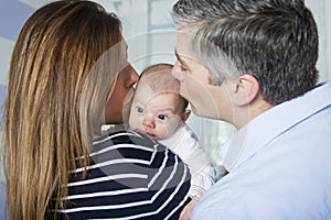 Proud Parents Holding Baby in the bedroom