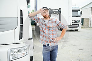 Proud Professional Trucker Standing in Front of His Truck. Trucking and Transportation Theme.