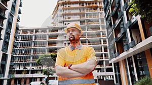 Proud serious young architect or engineer young man with crossed arms as a concept of professional construction supervision photo