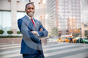 Proud successful businessman executive CEO african american, standing confidently with arms folded in downtown, financial building