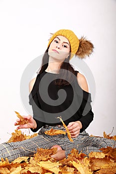 Proud teen girl sitting on dried leaves