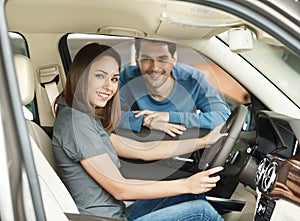 Proud of their new car. Beautiful young couple are examining a n