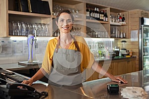 Proud waitress standing at counter