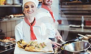 Proud woman chef cook in the kitchen with her food