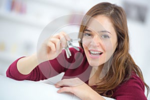 Proud young woman holding up set house keys photo