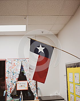 Proudly display of Texas flag in pre-kindergarten classroom near Dallas, modern preschooler class furniture, bulletin board, well