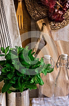 Provence rustic kitchen interior, wood cutting board, utensils, glass bottles, fresh herbs, linen towel on white background