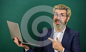 Provide accurate current information. Teacher wear eyeglasses hold laptop surfing internet. Bearded man modern laptop