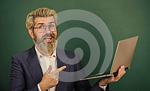 Provide accurate current information. Teacher wear eyeglasses hold laptop surfing internet. Bearded man modern laptop