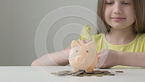 Provident economical little girl child put money into piggy bank saving for future needs. Savings, budget planning