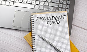 PROVIDENT FUND text written on a notebook on the laptop