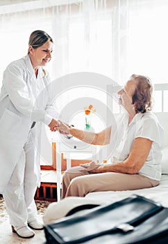 Providing care for elderly. Doctor visiting elderly patient at home.