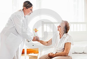 Providing care for elderly. Doctor visiting elderly patient at home.