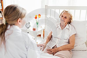 Providing care for elderly. Doctor visiting elderly patient at home.