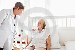 Providing care for elderly. Doctor visiting elderly patient at home.