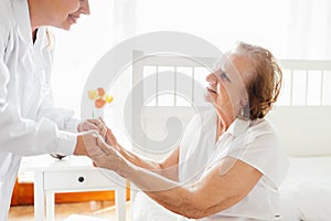 Providing care for elderly. Doctor visiting elderly patient at home.