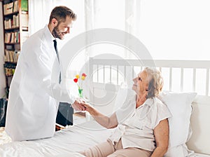 Providing care for elderly. Doctor visiting elderly patient at home.