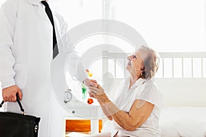 Providing care for elderly. Doctor visiting elderly patient at home.