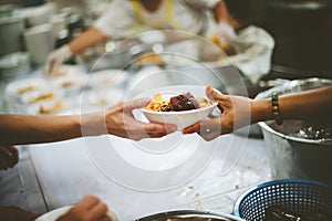 Providing free food to the poor Volunteers scooping out food to give charity to those who are hungry