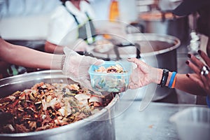 Providing free food to the poor : Volunteers scooping out food to give charity to those who are hungry