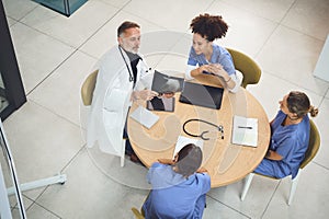 Providing insights relevant to their clinical discipline. a team of doctors analysing x-rays during a meeting in a