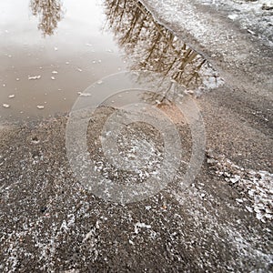 Provincial road with snow and puddle