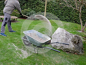 After pruning a bunch of lawn, gardeners apply silica white sand. for better structure and airiness against grass mold. load on a