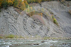 Prut river, autumn trees and geological mountain folds in Yaremche City, Ukraine