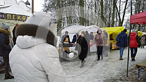 Festivities and trade fair in the city park. Crowd of people walking. Shopping tents on the street.