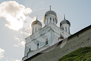 Pskov, Russia, September 6, 2023. The domes of the Trinity Cathedral over the Kremlin wall in the rays of the sun.